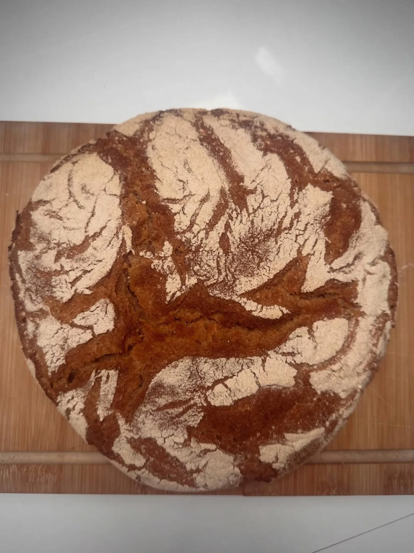 Grande miche de pain de campagne farinée sur une planche